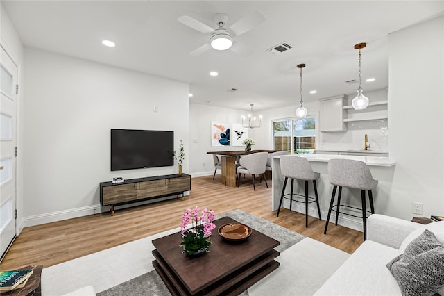 living area with baseboards, visible vents, recessed lighting, and light wood-style flooring