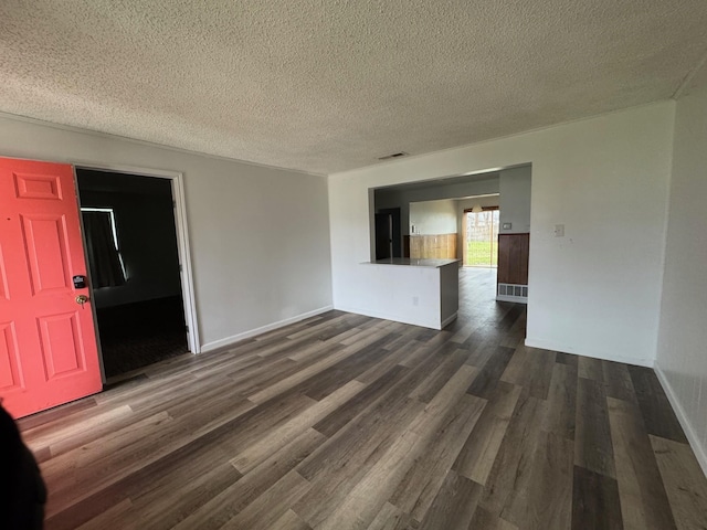 unfurnished room with dark hardwood / wood-style flooring and a textured ceiling