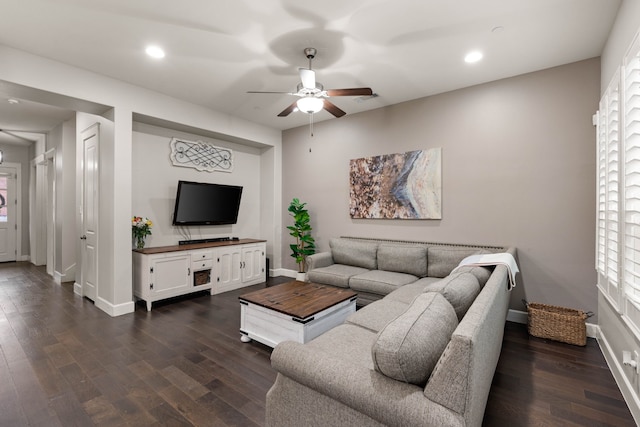 living room featuring ceiling fan, dark hardwood / wood-style flooring, and a healthy amount of sunlight