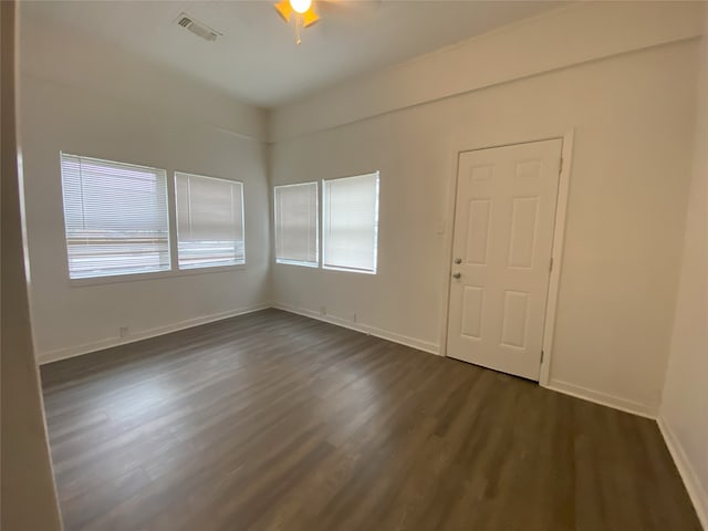 empty room with dark hardwood / wood-style floors and ceiling fan