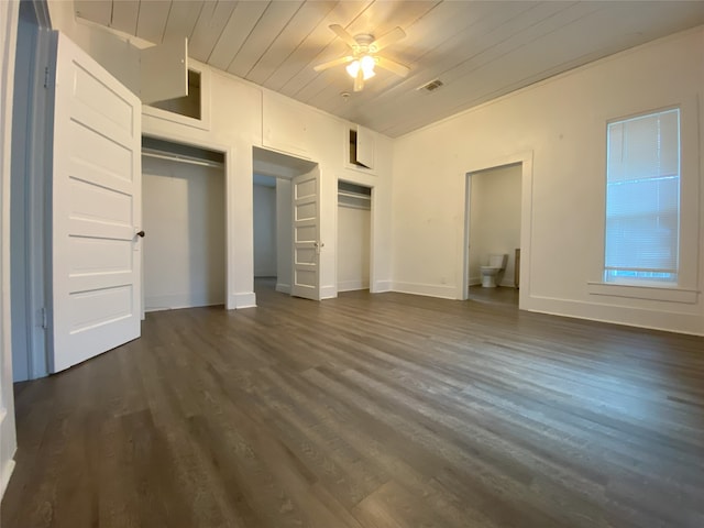 unfurnished bedroom with dark wood-type flooring, wooden ceiling, two closets, and ceiling fan