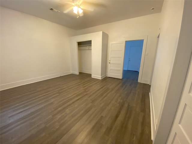 unfurnished bedroom with dark wood-type flooring, ceiling fan, and a closet