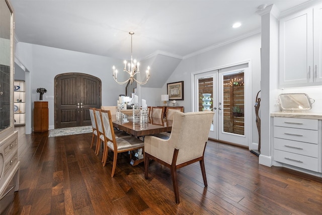 dining area featuring a notable chandelier, dark wood-type flooring, french doors, vaulted ceiling, and crown molding
