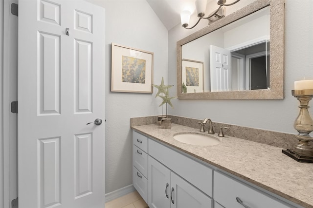 bathroom with lofted ceiling, tile patterned flooring, and vanity