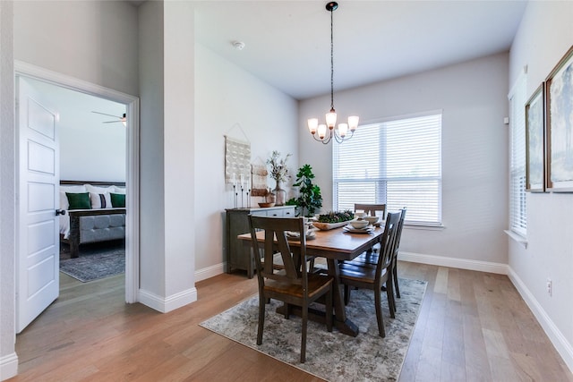 dining space with light hardwood / wood-style flooring and a chandelier