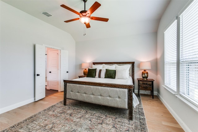 bedroom with light hardwood / wood-style floors, vaulted ceiling, and ceiling fan