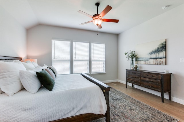 bedroom with hardwood / wood-style floors, lofted ceiling, and ceiling fan