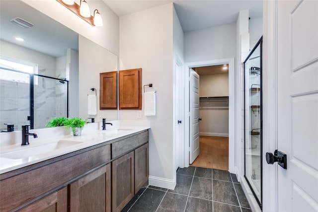 bathroom featuring a shower with shower door and vanity