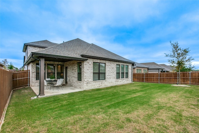 back of property featuring a patio and a yard