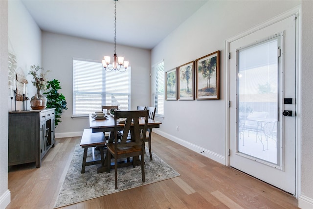 dining area featuring light wood-type flooring and a notable chandelier