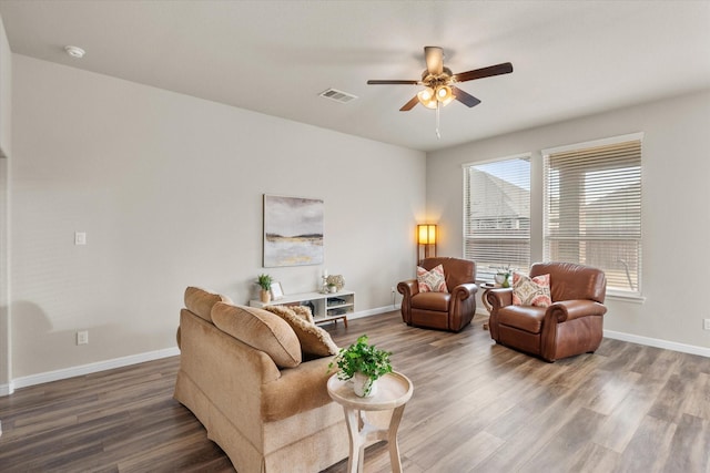 living room featuring baseboards, visible vents, and wood finished floors