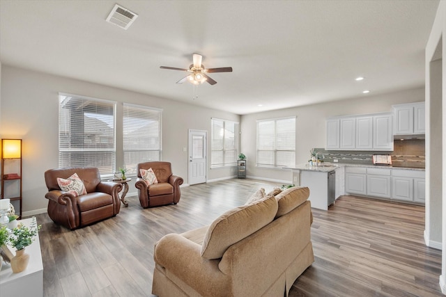 living area featuring recessed lighting, visible vents, light wood-style flooring, a ceiling fan, and baseboards