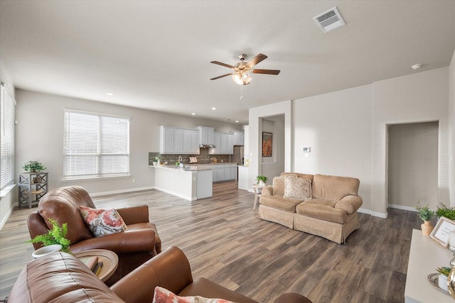 living area featuring baseboards, visible vents, a ceiling fan, wood finished floors, and recessed lighting