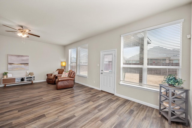 sitting room with ceiling fan, baseboards, and wood finished floors