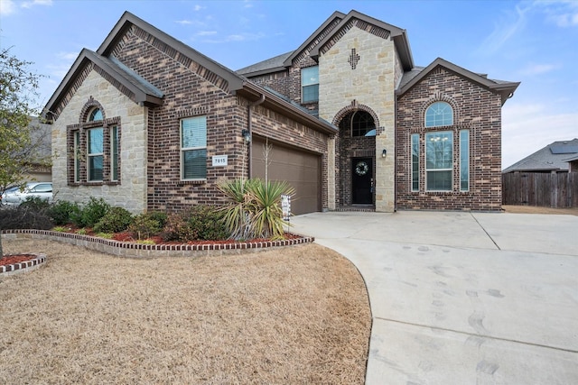 french country inspired facade with a garage, driveway, brick siding, and stone siding