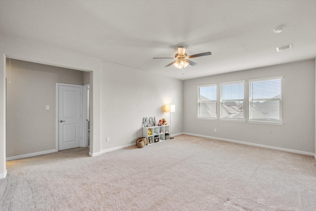 unfurnished room featuring carpet floors, ceiling fan, visible vents, and baseboards