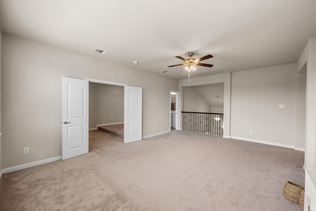 empty room featuring ceiling fan, carpet flooring, visible vents, and baseboards