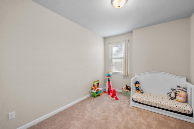 carpeted bedroom with a nursery area and baseboards