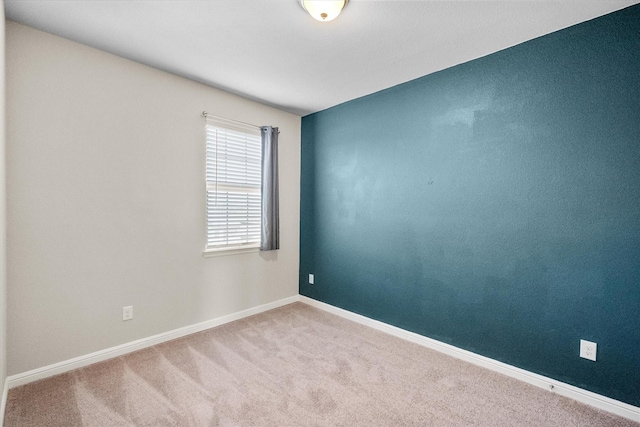 carpeted spare room with baseboards