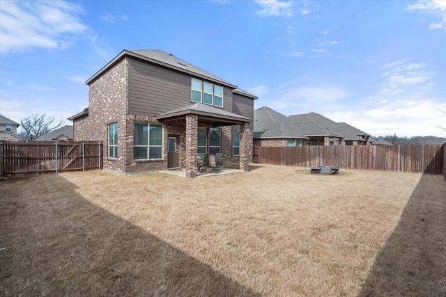 rear view of property with a patio area, brick siding, and a fenced backyard