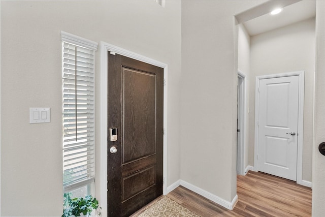 foyer with light wood-type flooring and baseboards