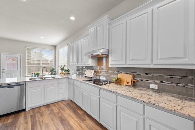 kitchen featuring dishwasher, light wood-style flooring, black electric stovetop, under cabinet range hood, and a sink