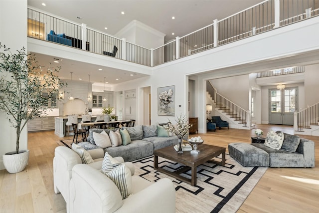 living room featuring light wood-type flooring and a towering ceiling