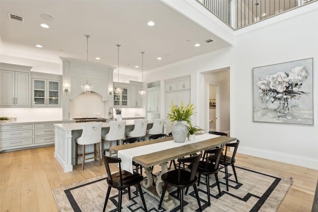 dining space with crown molding and light hardwood / wood-style floors