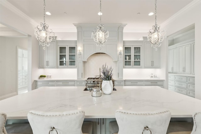 kitchen featuring crown molding, a breakfast bar, a spacious island, and decorative light fixtures