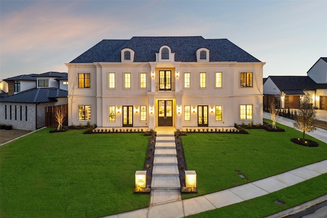 view of front facade with french doors and a lawn