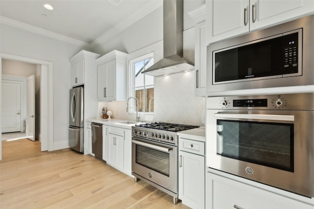 kitchen featuring appliances with stainless steel finishes, sink, white cabinetry, and island exhaust hood