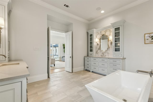 bathroom with ornamental molding, vanity, a bath, and wood-type flooring