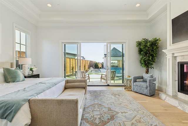 bedroom with access to exterior, light hardwood / wood-style floors, multiple windows, and a high end fireplace