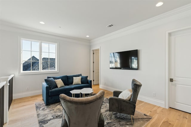 living room with ornamental molding and light hardwood / wood-style flooring