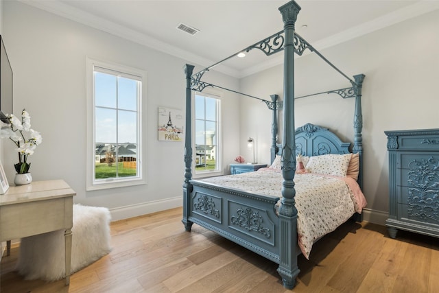 bedroom with light hardwood / wood-style flooring and crown molding