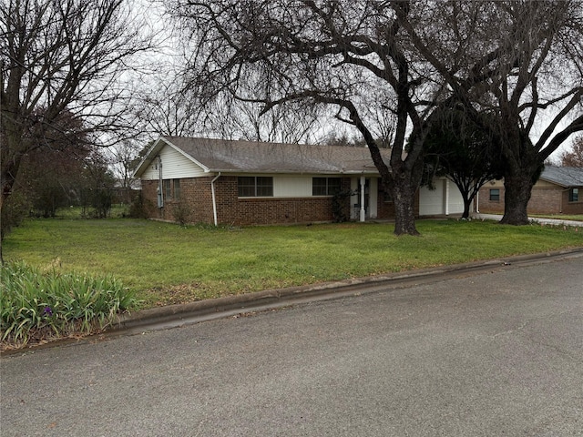 single story home featuring a garage and a front lawn