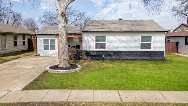 view of front facade featuring fence, brick siding, and a front yard