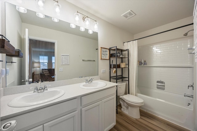 full bathroom with shower / tub combo with curtain, toilet, hardwood / wood-style flooring, and vanity