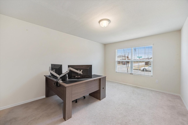 office area with a textured ceiling and light carpet