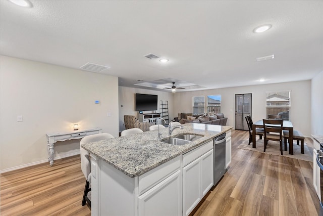 kitchen featuring sink, a center island with sink, white cabinetry, and light hardwood / wood-style flooring