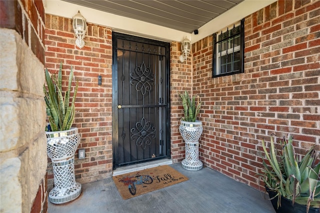 doorway to property with brick siding