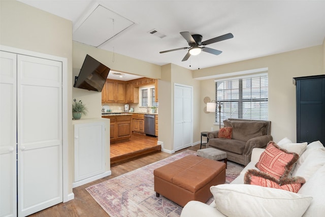 living room with ceiling fan and light hardwood / wood-style flooring