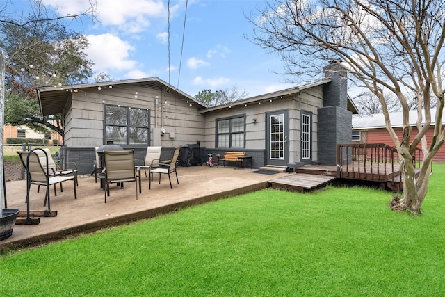 rear view of property with a patio, a yard, and a deck