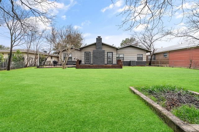 back of house featuring a lawn and a deck