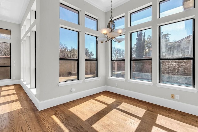 unfurnished sunroom featuring a healthy amount of sunlight and a notable chandelier