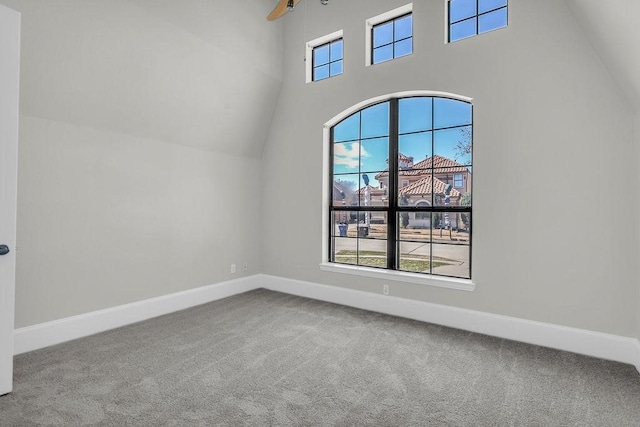 additional living space featuring carpet flooring, ceiling fan, a towering ceiling, and baseboards