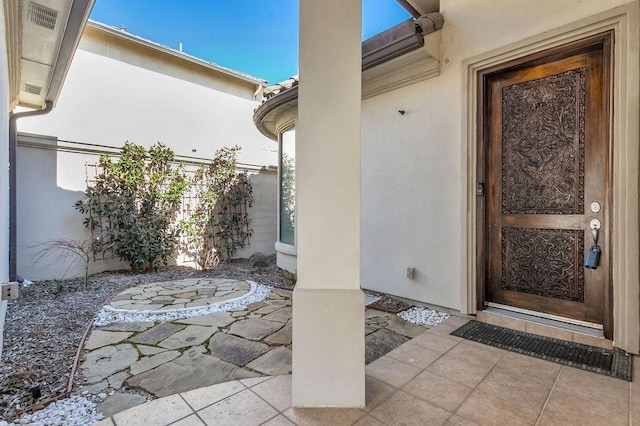 doorway to property featuring stucco siding