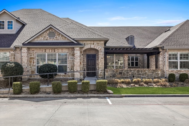 french provincial home with stone siding and roof with shingles