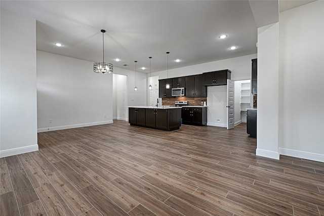 kitchen featuring a center island, pendant lighting, dark hardwood / wood-style flooring, and backsplash