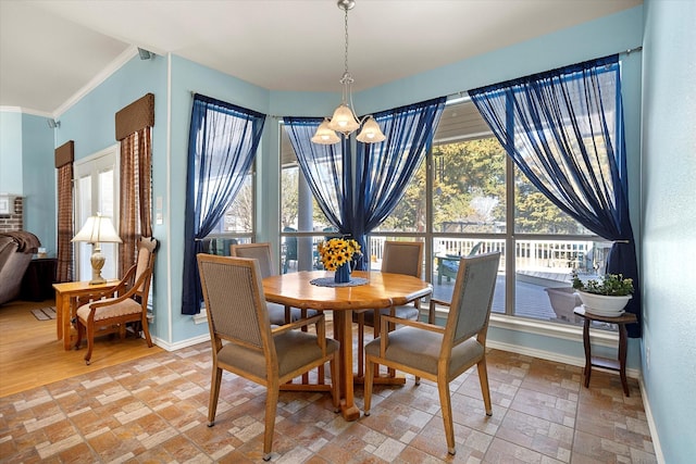 dining area with ornamental molding and a chandelier